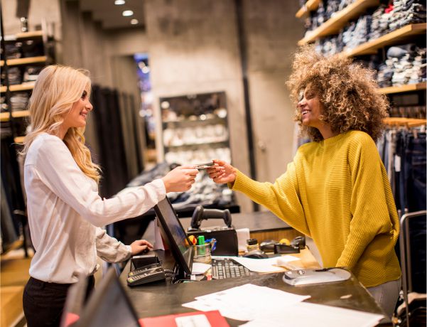 Attractive woman customer paying with credit card in retail store